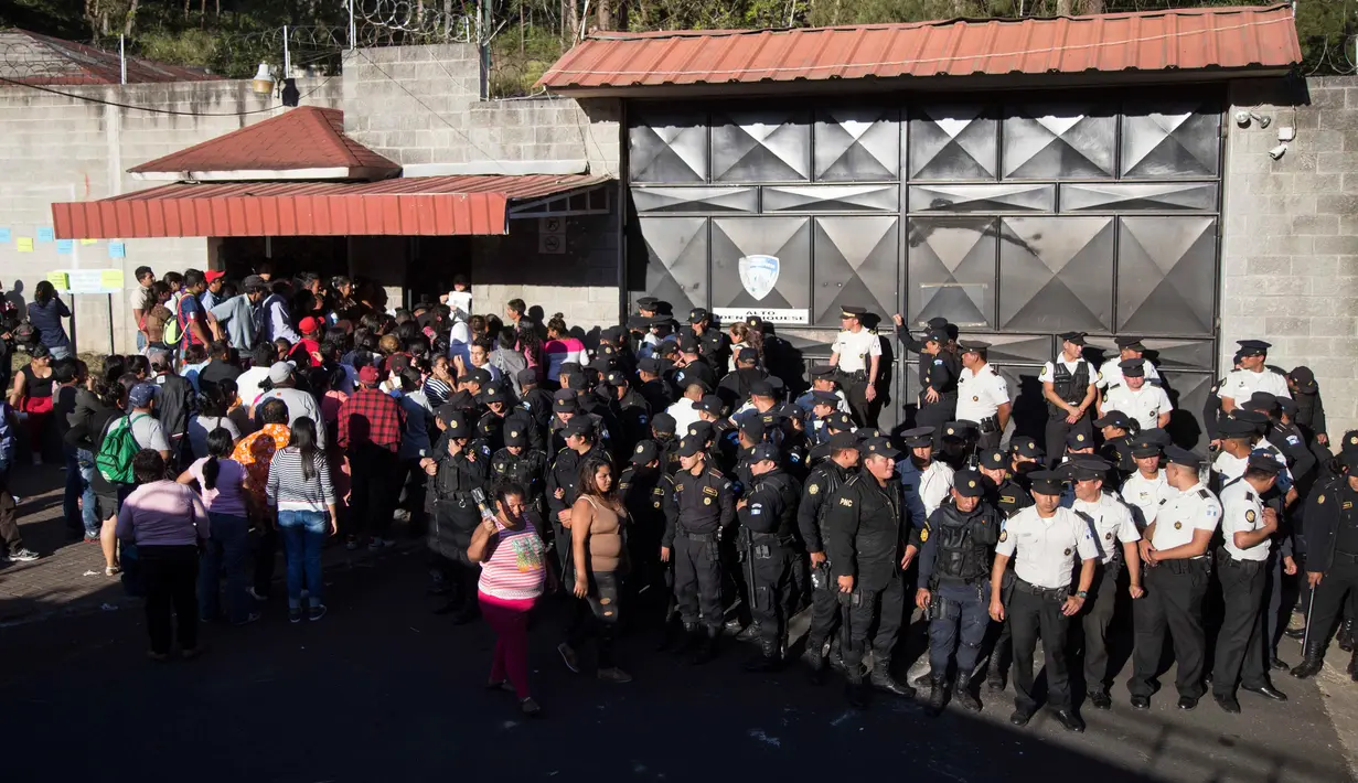 Aparat kepolisian menjaga pintu masuk menyusul kebakaran sebuah asrama penampungan anak-anak di Guatemala, Rabu (8/3). Kebakaran terjadi setelah 60 remaja mengamuk dan membakar kasur karena perlakuan buruk yang mereka terima. (AP Photo/Luis Soto)
