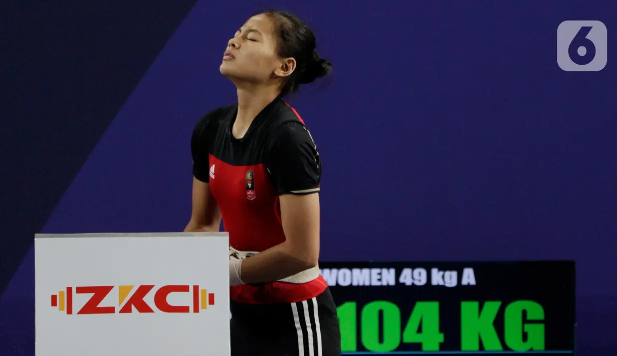Lifter Windy Aisyah bersiap melakukan angkatan saat SEA Games 2019 cabang angkat besi nomor 49 kg di Stadion Rizal Memorial, Manila, Minggu (1/12/2019). Windy Aisyah meraih emas dengan total angkatan 104 kg. (Bola.com/M Iqbal Ichsan)