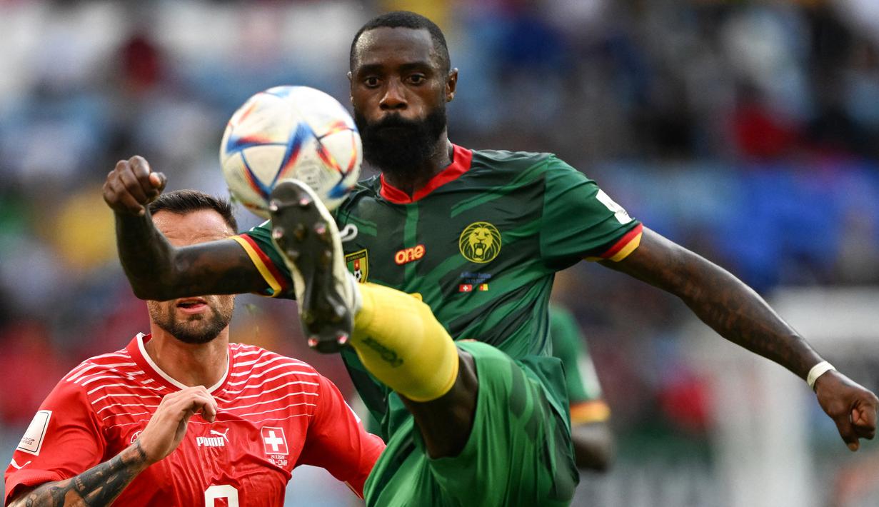 Bek Kamerun, Nicolas Nkoulou mengontrol bola di depan striker Swiss pada laga Grup G putaran final Piala Dunia Qatar 2023 di Al-Janoub Stadium, Al-Wakrah, Doha (24/11/2022). Nicolas Nkolou tampil di Premier League Liga Inggris bersama watford hanya satu musim pada 2021/2022. Jarang dimainkan, ia hanya tampil dalam 3 laga di Premier League Liga Inggris. (AFP/Kirill Kudryavtsev)