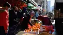 Orang-orang membeli bahan makanan dan berjalan-jalan di kawasan Chinatown di New York City, 5 Februari 2021. Tahun Baru Imlek akan jatuh Jumat depan, 12 Februari, dan itu harusnya menjadi waktu tersibuk untuk Chinatown, tetapi tidak pada tahun 2021 saat pandemi COVID-19 mewabah. (Angela Weiss/AFP)