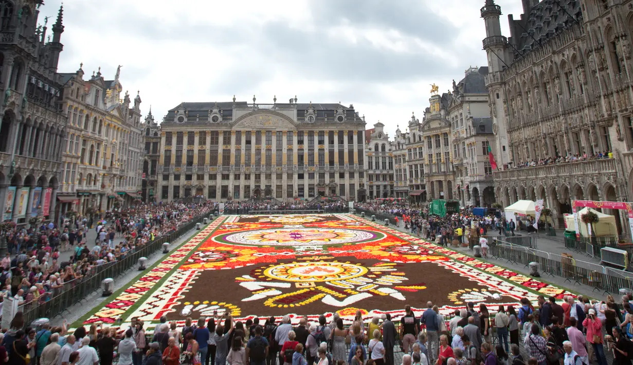 Pengunjung menyaksikan Karpet Bunga Brussels di Grand Place, Brussels, Belgia, Kamis (16/8). Karya ini didedikasikan kepada orang-orang Guanajuato di Meksiko yang kaya akan budaya dan tradisi bunga. (AP Photo/Virginia Mayo)
