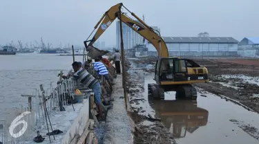 Alat berat dikerahkan untuk menyelesaikan proyek pembangunan tanggul di Pantai Muara Baru, Jakarta, Rabu (2/12). Proyek tanggul tersebut bertujuan untuk menahan banjir rob yang sering melanda kawasan Muara Baru. (Liputan6.com/Gempur M Surya)