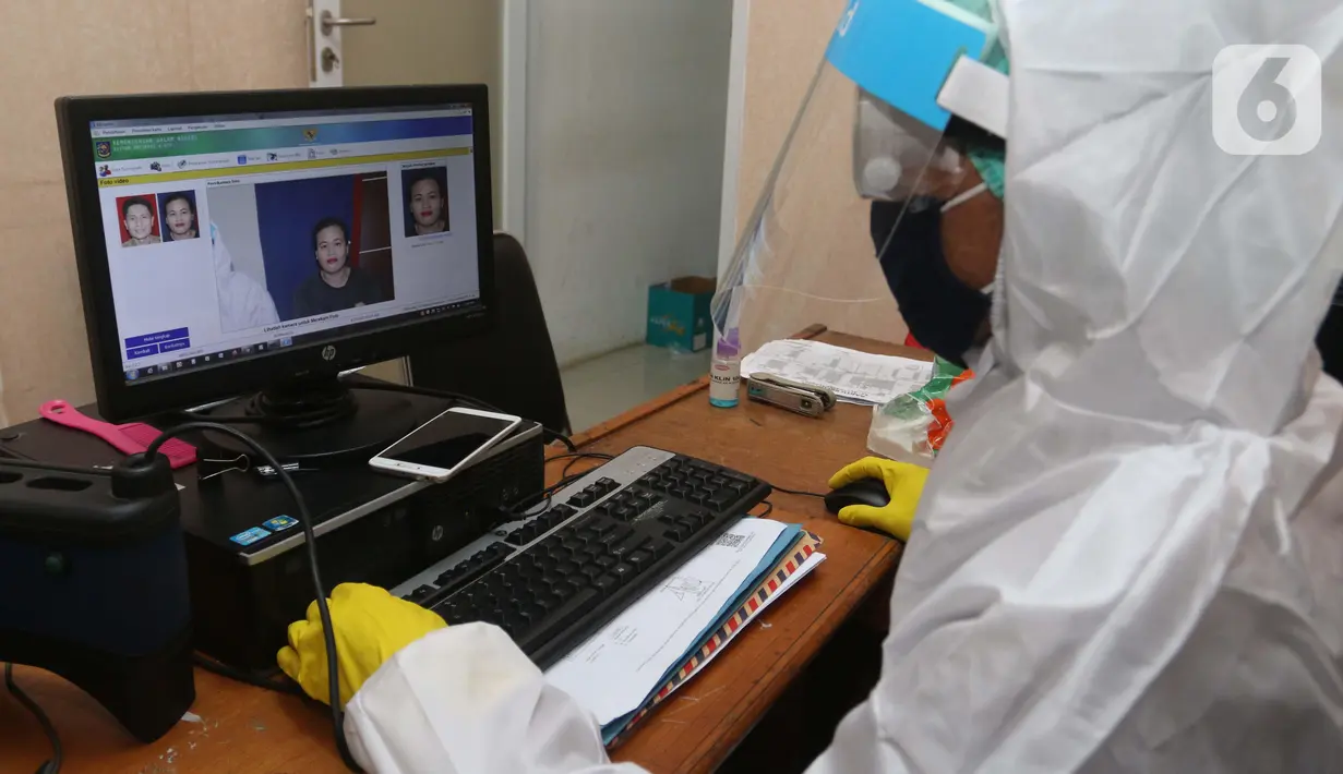 Petugas menggunakan Alat Pelindung Diri (APD) saat melayani warga yang mengajukan pembuatan KTP Elektronik di Pondok Aren, Tangerang Selatan, Senin (15/6/2020). Penggunaan APD ini bertujuan meminimalisir kontak fisik sebagai upaya pencegahan penularan Corona COVID-19. (Liputan6.com/Angga Yuniar)