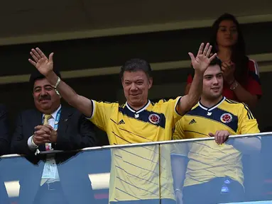 Presiden Kolombia, Juan Manuel Santos (tengah), menyaksikan langsung laga Los Cafeteros kontra Pantai Gading di Stadion National Mane Garrincha, Brasil, (19/6/2014). (AFP PHOTO/Eitan Abramovich)