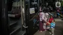 <p>Seorang warga bersama anaknya bersiap menaiki bus tujuan mereka untuk mudik bareng gratis BUMN di kawasan Jakarta, Rabu (27/4/2022). Program mudik gratis merupakan salah satu solusi untuk mengantisipasi potensi kepadatan lalu lintas pada masa Lebaran.(Liputan6.com/Faizal Fanani)</p>
