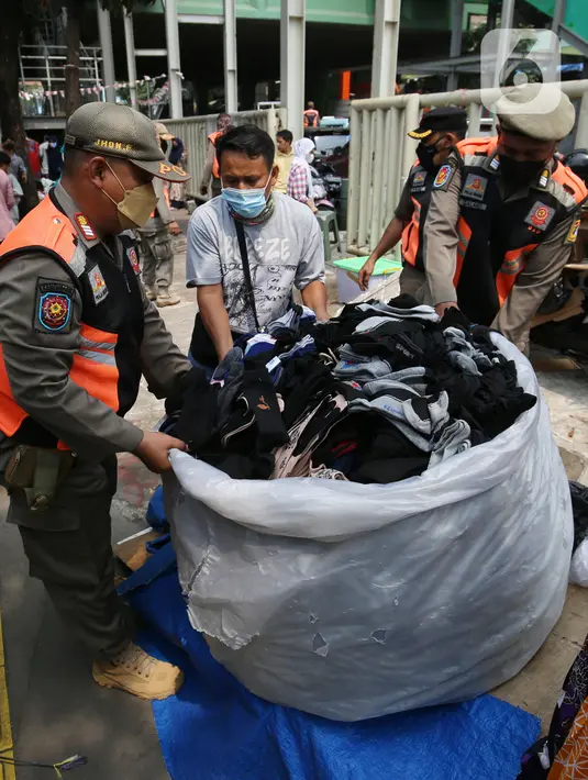 Petugas Satpol PP melakukan penertiban kepada pedagang kaki lima (PKL) yang bandel berjualan di trotoar Pasar Tanah Abang, Jakarta, Senin (4/10/2021). Penertiban dilakukan untuk memberikan kenyamanan dan keamanan bagi para pengguna jalan yang melintas di trotoar tersebut. (Liputan6.com/Angga Yuniar)