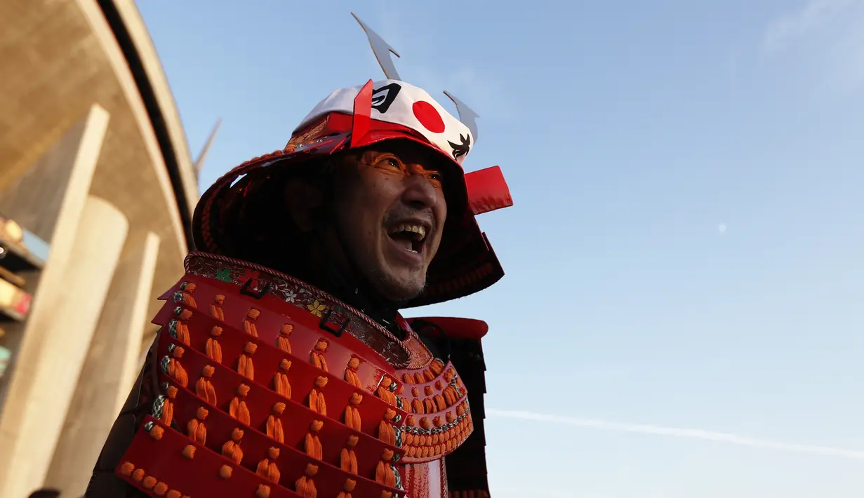 Seorang fans Jepang mengenakan kostum samurai berpose jelang pertandingan  Rugby World Cup 2019 antara Jepang dan Samoa di luar City of Toyota Stadium, Tokyo, Jepang (5/10/2019). (AFP Photo/Adrian Dennis)