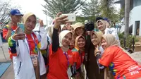 Volunteer Asian Games 2018 berselfie ria di tengah kesibukan bertugas (Liputan6.com/Nefri Inge)