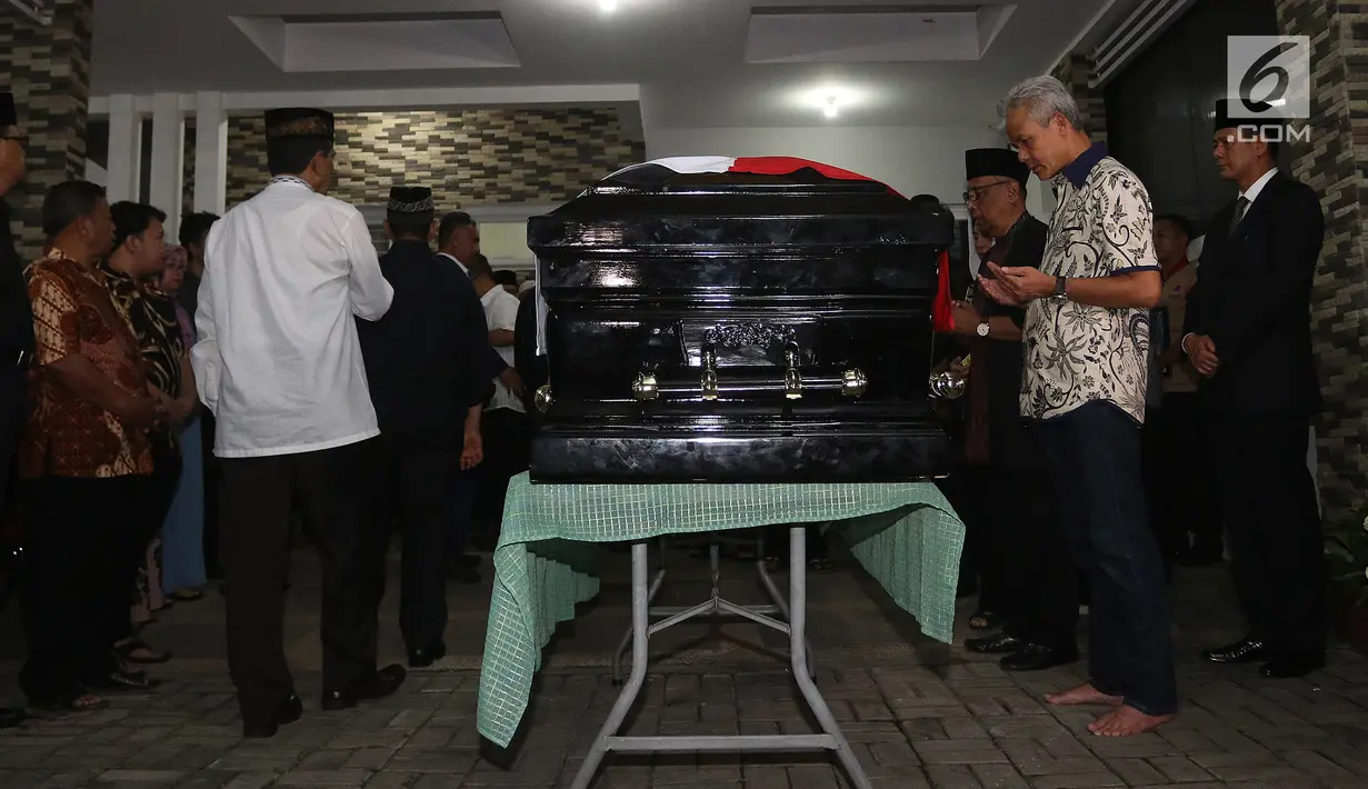 Gubernur Jawa Tengah Ganjar Pranowo berdoa  di depan peti jenazah Kepala Pusat Data Informasi dan Humas Badan Nasional Penanggulangan Bencana (BNPB) Sutopo Purwo Nugroho saat melayat ke rumah duka di Raffles Hils, Cimanggis, Depok, Jawa Barat, Minggu (7/7/2019). (Liputan6.com/Herman Zakharia)