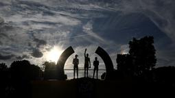 Siluet Romain Bardet (kiri), juara Tour de France 2016 Christopher Froome (tengah), dan Nairo Quintana, saat berada di podium setelah etape terakhir finis di Champs-Elysees, Paris, (24/7/2016). (AFP/Jeff Pachoud)