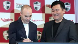 Mantan pemain Barcelona, Andres Iniesta (kiri) didampingi pemilik klub Vissel Kobe, Hiroshi Mikitani menandatangani dokumen saat konferensi pers di Tokyo, Jepang, Kamis (24/5). Iniesta resmi bergabung dengan Vissel Kobe. (AP Photo/Eugene Hoshiko)