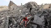 Seorang anak perempuan Palestina mencari jalan di antara reruntuhan bangunan yang dihantam serangan Israel di kamp pengungsi Bureij, Jalur Gaza tengah pada 10 Juli 2025. (Eyad BABA/AFP)