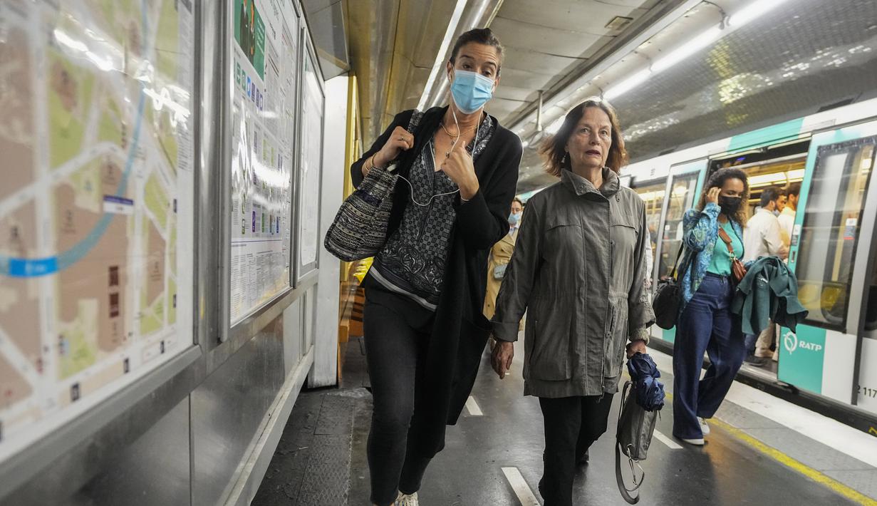 Seorang perempuan mengenakan masker bergegas di peron kereta bawah tanah di Paris, Prancis, Kamis (30/6/2022). Kasus virus corona covid-19 meningkat dengan cepat di Prancis dan negara-negara Eropa lainnya setelah pembatasan COVID-19 dicabut pada musim semi. (AP Photo/Michel Euler)