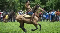Warga Sumba menunggang kuda membawa busur pada sebuah ritual pertempuran Festival Pasola tahunan, di Pulau Sumba. (AFP Photo/Romeo Gacad)