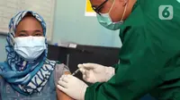 Vaksinator menyuntikkan vaksin COVID-19 kepada tenaga kesehatan yang bertugas di Puskesmas Jurang Mangu, Tangerang Selatan, Jumat (15/1/2021). Program vaksinasi COVID-19 tahap pertama kepada tenaga kesehatan mulai dilakukan di berbagai daerah di Indonesia. (Liputan6.com/Angga Yuniar)