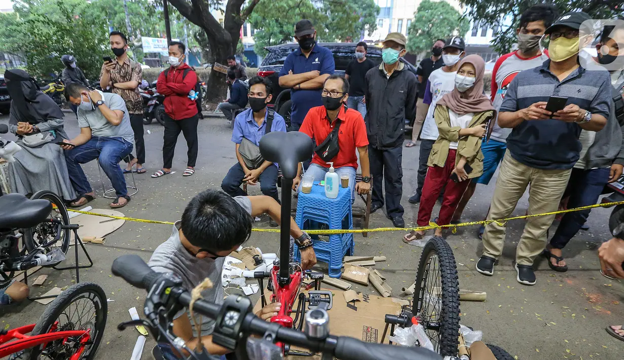 Warga antre menunggu pesanan sepeda yang sedang dirakit di Toko Sepeda Maju Royal, Cipondoh, Kota Tangerang, Kamis (11/6/2020). Menjelang new normal pada 15 Juni, warga mulai berburu membeli sepeda lipat untuk berolahraga dan aktivitas kerja. (Liputan6.com/Fery Pradolo)