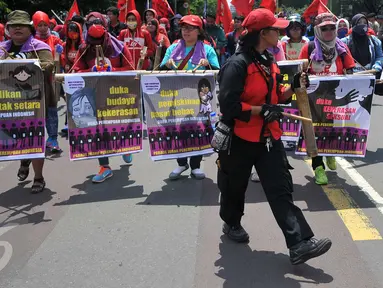 Massa perempuan dari beberapa elemen melakukan long march menuju Istana Presiden, Jakarta, Selasa (8/3). Aksi memperingati Hari Perempuan Internasional ini menuntut pemerintah menegakkan keadilan terhadap perempuan Indonesia. (Liputan6.com/Gempur M Surya)