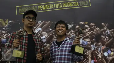 Juara 2 Kategori Spot News pewarta foto Liputan6.com, Faizal Fanani (kiri) dan juara 1 Kategori General News, Immanuel Antonius berpose memegang trofi Anugerah Pewarta Foto Indonesia (APFI) ke-VI di Bandung, Sabtu (9/4). (Liputan6.com/Immanuel Antonius)