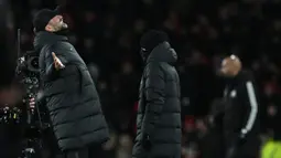 Pelatih Liverpool, Jurgen Klopp (kiri), meluapkan kebahagiannya setelah timnya memenangkan pertandingan putaran ketiga FA Cup 2023/2024 melawan Arsenal yang berlangsung di Emirates Stadium, Minggu (7/1/2024) malam WIB. (AFP/Ben Stansall)