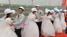 Sejumlah pekerja melaksanakan upacara pernikahan di tempat proyek mereka bekerja di sebuah bandara yang sedang dalam proses pembuatan, Beijing, Senin (12/12). Bandara baru ini dijadwalkan akan selesai pada 2019. (AFP PHOTO)