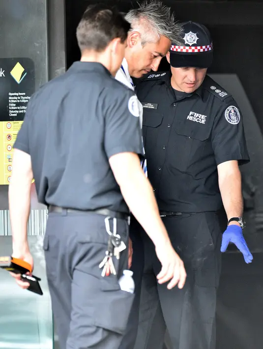 Petugas layanan darurat menyelidiki lokasi kebakaran yang terjadi di sebuah kantor cabang Commonwealth Bank of Australia, di Melbourne , Jumat (18/11). Kejadian ini menyebabkan 27 orang terluka, tiga di antaranya anak-anak. (AAP/Julian Smith/via REUTERS)