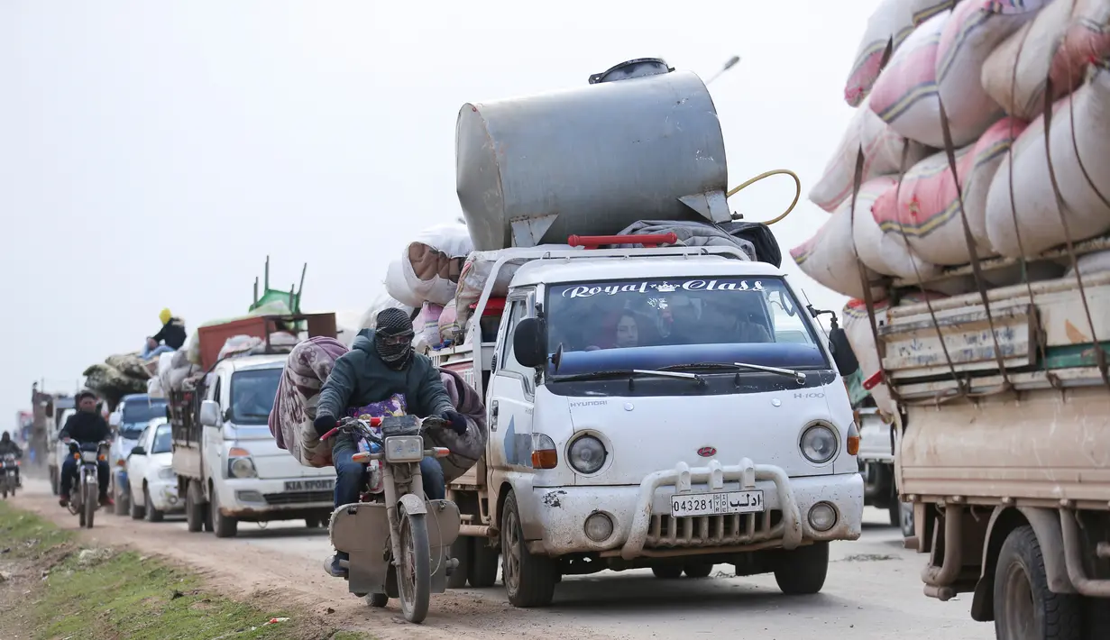 Warga melarikan diri menuju perbatasan Turki di Provinsi Idlib, Suriah, Rabu (29/1/2020). Kemajuan serangan pasukan pemerintah Suriah yang didukung Rusia atas Idlib memaksa ratusan ribu warga mengungsi ke tempat lebih aman. (AP Photo/Ghaith Alsayed)