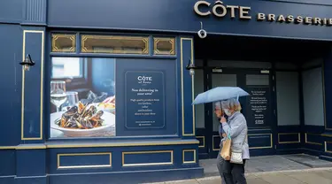 Orang-orang berjalan melewati sebuah restoran yang tutup sementara di London, Inggris, pada 13 Oktober 2020. Tingkat pengangguran Inggris melonjak ke level tertinggi dalam tiga tahun terakhir di angka 4,5 persen untuk periode Juni-Agustus 2020. (Xinhua/Han Yan)