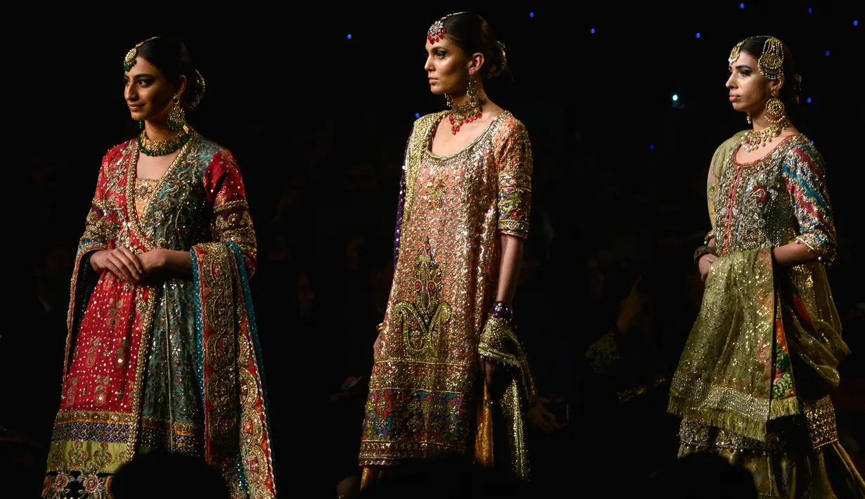 Model berjalan di runway membawakan busana rancangan desainer Dnnus Dlrar selama Pantene Hum Bridal Couture Week di Lahore, Minggu (9/12). Mereka memperagakan kreasi gaun pengantin dari sejumlah desainer ternama di Pakistan. (ARIF ALI / AFP)