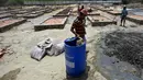 Para buruh bekerja membangun tempat kremasi di ladang kosong di New Delhi, India, Rabu (5/5/2021). Jumlah kasus COVID-19 di India meningkat pesat dibanding awal April lalu ketika masih di kisaran 15 juta. (Money SHARMA/AFP)