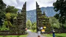 Pemandangan pura yang ikonik ini sangat dikenal oleh masyarakat Indonesia terlebih pernah diabadikan pada lembaran uang kertas pecahan Rp 50.000.-. Tampak dalam foto,wisatawan mengambil foto Gerbang Handara di dekat Bedugul, Bali, pada Jumat 7 November 2025. (Mladen ANTONOV/AFP)