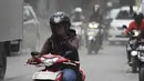 Pengendara motor menggunakan masker untuk menghindari debu saat melintasi Jalan Kemukus, Tamansari, Jakarta, Senin (24/11/2014). (Liputan6.com/Faizal Fanani)