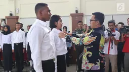 Menpora Imam Nahrawi menyematkan tanda nama pada perwakilan peserta Diklat Paskibraka Nasional 2018 di Wisma Soegondo Cibubur, Jakarta, Kamis (26/7). Diklat diikuti 68 siswa terbaik dari 34 provinsi di Indonesia. (Liputan6.com/Helmi Fithriansyah)