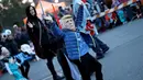 Seorang anak laki-laki memakai topeng calon presiden dari Partai Republik, Donald Trump saat acara tahunan Parade Nyack Halloween di Desa Nyack, New York, AS (29/10). (Reuters/Mike Segar)