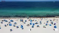 Pandangan udara menunjukkan orang-orang berada di atas pasir Miami Beach di Florida, Rabu (10/6/2020). Pantai Miami dibuka hari ini untuk pertama kalinya setelah hampir tiga bulan ditutup guna menekan jumlah penyebaran corona Covid-19. (CHANDAN KHANNA / AFP)