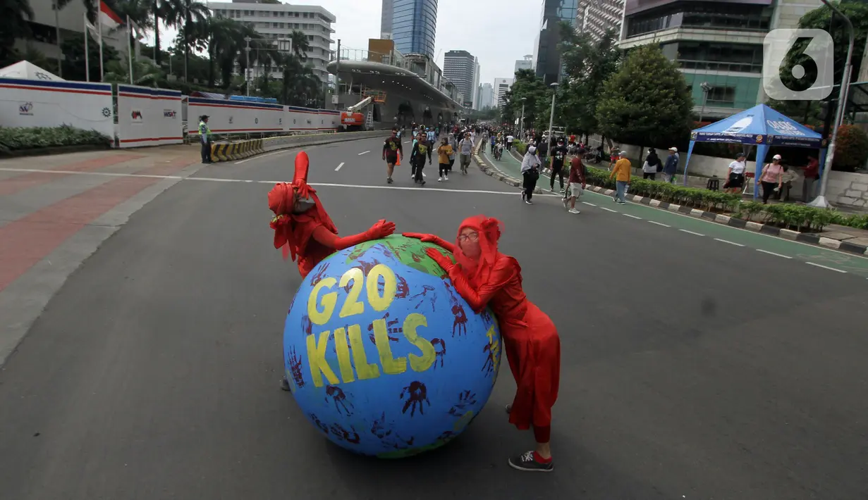 Aktivis lingkungan dari Extinction Rebellion Indonesia melakukan aksi penanganan mitigasi krisis iklim di Bundaran HI, Jakarta, Minggu (13/11/2022). Aktivis menuntut kepedulian negara-negara peserta KTT G20 untuk melakukan transisi energi yang berkelanjutan dan berkeadilan dalam krisis iklim. (merdeka.com/Arie Basuki)