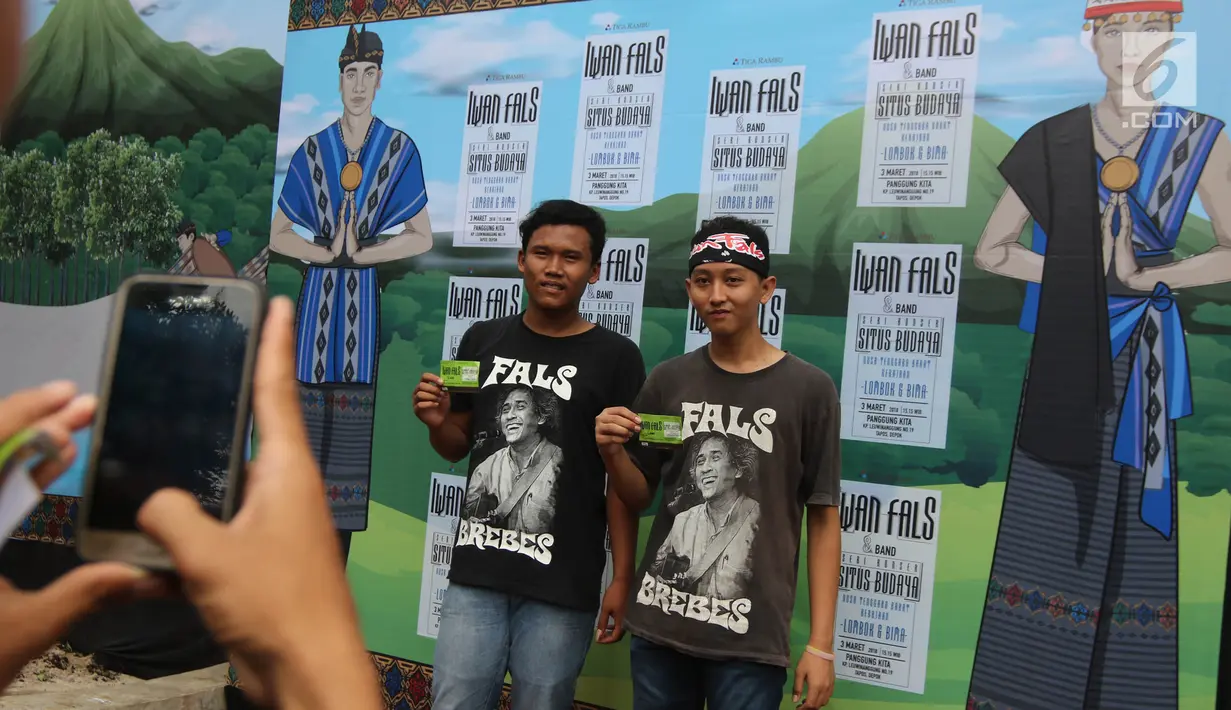 Penonton berpose memegang tiket Konser Situs Budaya Iwan Fals dan Band di Panggung Kita, Depok, Sabtu (3/3). Para pengunjung konser sebagian besar merupakan anggota komunitas Orang Indonesia (OI), kelompok penggemar Iwan Fals. (Liputan6.com/Arya Manggala)