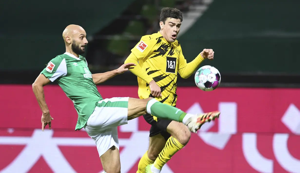 Gelandang Borussia Dortmund, Giovanni Reyna (kanan) berebut bola dengan bek Werder Bremen, Omer Toprek, dalam laga lanjutan Bundesliga Liga Jerman 2020/21 pekan ke-12 di Weserstadion, Bremen, Rabu (15/12/2020). Dortmund menang 2-1 atas Bremen. (AP/Carmen Jaspersen/Pool).