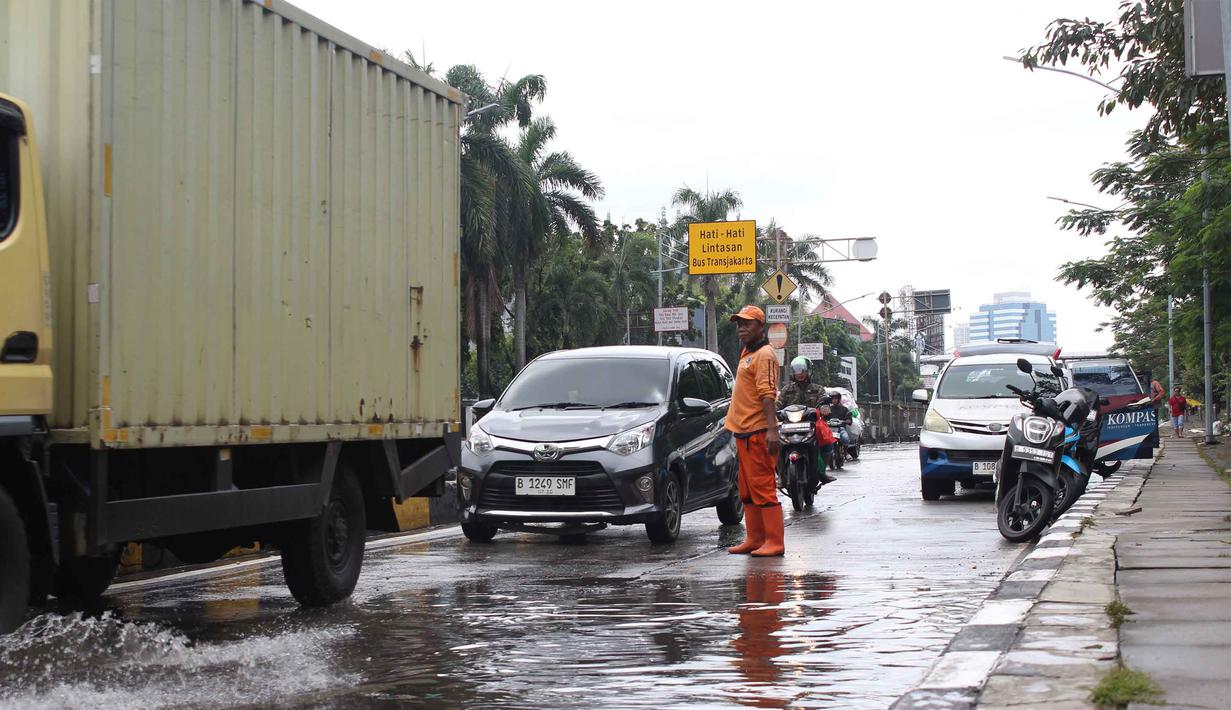 Saat ini, arus lalu lintas di Jalan Gunung Sahari Raya, Jakarta mulai kembali normal. Tampak dalam foto, petugas Penanganan Prasarana dan Sarana Umum (PPSU) DKI Jakarta mengatur arus lalu lintas di Jalan Gunung Sahari Raya atau tepat di depan Mangga Dua Square, Jakarta, Selasa (13/1/2026). (merdeka.com/magang/Rendi Saputra)