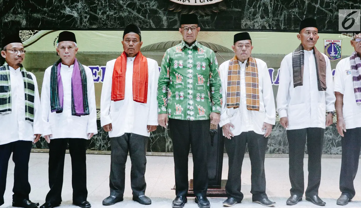 Gubernur DKI Jakarta Anies Baswedan foto bersama marbot masjid Jakarta yang diberangkatkan untuk umrah di Balai Kota, Jumat (9/11). Pada tahun lalu, jumlah marbot masjid Jakarta yang diberangkatkan umrah hanya 100 orang. (Liputan6.com/Immanuel Antonius)