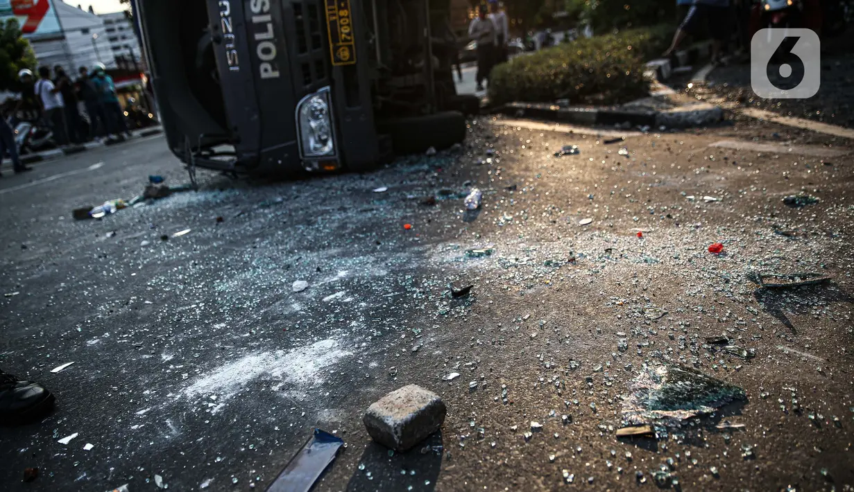Batu berserakan dekat sebuah mobil polisi yang dirusak massa saat bentrok di kawasan Pejompongan, Jakarta, Rabu (7/10/2020). (Liputan6.com/Faizal Fanani)