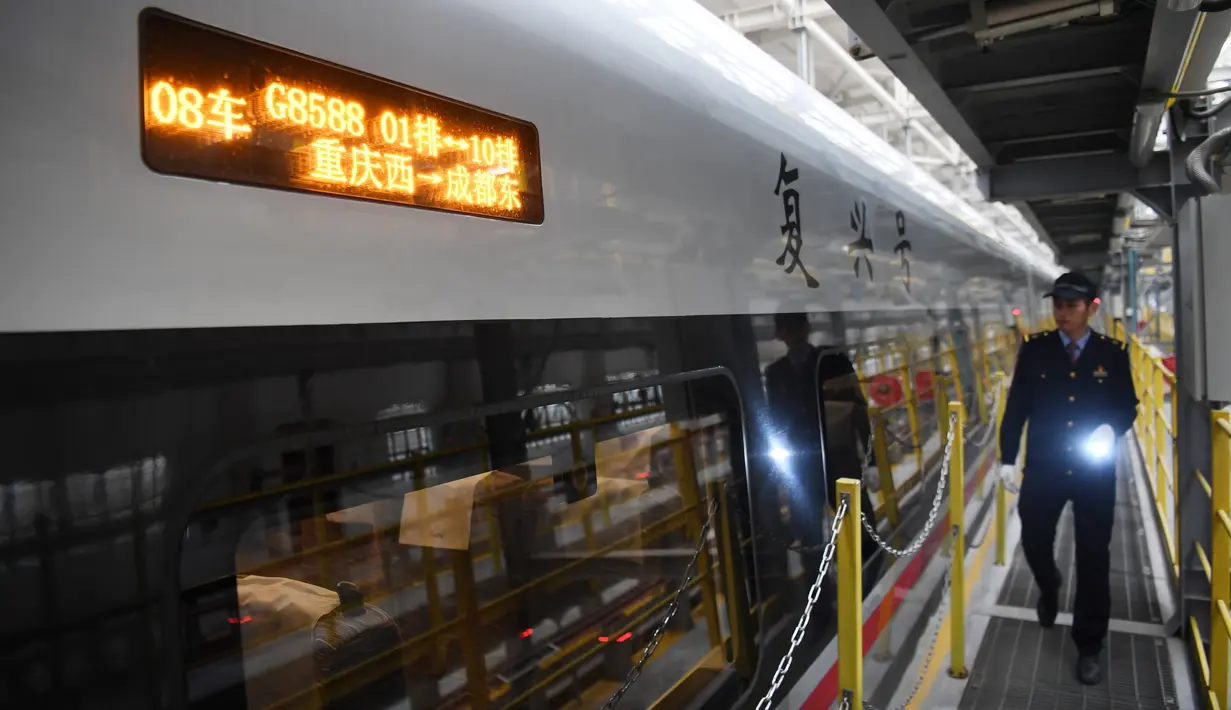 Seorang mekanik berjalan melewati kereta peluru Fuxing CR400AF di stasiun pemeliharaan depo gerbong kereta di Kota Chongqing, China (23/12/2020). Kereta ini melayani perjalanan dari Stasiun Shapingba di Chongqing menuju Stasiun Chengdu Timur di Chengdu, Provinsi Sichuan, China barat. Xinhua/Tang Yi)
