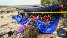 Pengungsi Rohingya berkumpul dalam tenda di pantai di Pulau Sabang, Provinsi Aceh, Indonesia, Minggu (3/12/2023). Lebih dari 100 pengungsi Rohingya, termasuk perempuan dan anak-anak, mendarat di pantai Aceh pada tanggal 2 Desember 2023 dini hari. (CHAIDEER MAHYUDDIN/AFP)