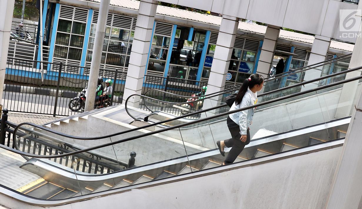 Warga menaiki anak tangga eskalator yang tidak berfungsi di Terminal Manggarai, Jakarta, Jumat (23/3). Eskalator yang rusak tersebut tidak kunjung diperbaiki. (Liputan6.com/Immanuel Antonius)