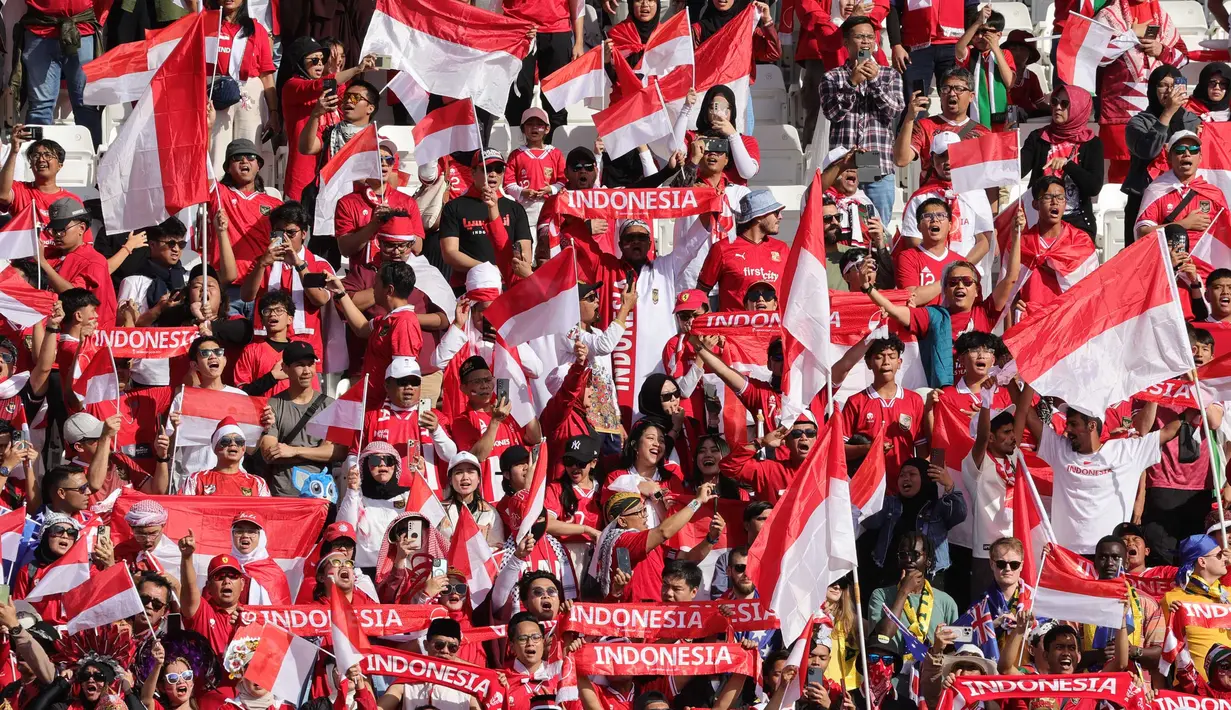 Suporter tim Garuda bersorak selama pertandingan sepak bola Piala Asia AFC Qatar 2023 antara Australia dan Indonesia di Stadion Jassim bin Hamad di Doha pada 28 Januari 2024. (Giuseppe CACACE/AFP)