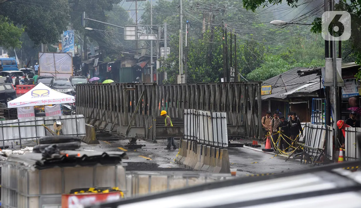 Aktivitas pekerja di Jembatan Cikreteg yang longsor di akses jalan nasional Bogor-Sukabumi, Caringin, Kabupaten Bogor, Jawa Barat, Kamis (2/3/2023). Ruas jalan Jembatan Cikereteg longsor pada Senin (27/2/2023) pukul 11.00 WIB akibat tingginya intensitas hujan di wilayah tersebut sehingga semua arus lalu lintas kendaraan menuju ke lokasi itu ditutup total dan kendaraan roda empat dialihkan lewat jalan tol. (merdeka.com/Arie Basuki)