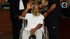 Terdakwa kasus dugaan suap dan penerimaan gratifikasi Lukas Enembe melambaikan tangan saat sidang putusan di Pengadilan Tipikor, Jakarta, Kamis (19/10/2023). Majelis Hakim menjatuhkan hukuman kepada Gubernur nonaktif Papua tersebut selama 8 tahun penjara dan denda Rp 500 juta subsider 4 bulan kurungan serta hukuman tambahan tidak dipilih dalam jabatan publik selama 5 tahun setelah menjalani hukuman. (Liputan6.com/Herman Zakharia)