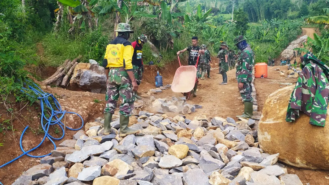 Belasan anggota TNI tengah melaksanakan pengerjaan jalan dalam program TMMD ke 108 Makodim 0611 Garut, di Desa Wanakerta, Garut, Jawa Barat.