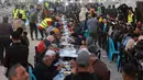 Antusiasme menyambut Ramadan tetap terasa di tengah kondisi sebagian besar warga yang telah kehilangan orang terkasih akibat perang berkepanjangan antara Israel dan Hamas di hampir seluruh wilayah Gaza. Tampak dalam foto, warga Palestina berkumpul untuk berbuka puasa bersama yang diselenggarakan oleh Yayasan IHH Turki, di tengah reruntuhan bangunan yang hancur di Kota Gaza pada Rabu 18 Februari 2026. (Omar AL-QATTAA/AFP)