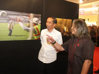 Presiden Joko Widodo atau Jokowi melihat pameran foto 'Membangun Indonesia'  di Jakarta, Selasa (12/11/2019). Pameran foto Membangun Indonesia itu menampilkan sejumlah capaian kinerja pemerintahan Presiden Joko-Widodo dan Wakil Presiden Jusuf Kalla. (Liputan6.com/Angga Yuniar)