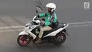 Pengendara sepeda motor mengoperasikan gawainya saat berkendara di Jakarta, Jumat (8/2). Mengoperasikan GPS saat mengemudi dinilai dapat mengganggu konsentrasi. (Liputan6.com/Immanuel Antonius)